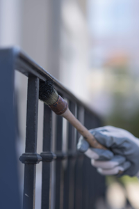 Application d'une peinture métal antirouille teintée en noir ou gris anthracite sur une clôture