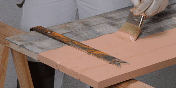 Application d'une peinture microporeuse pour le bois extérieur teintée rose sur un volet